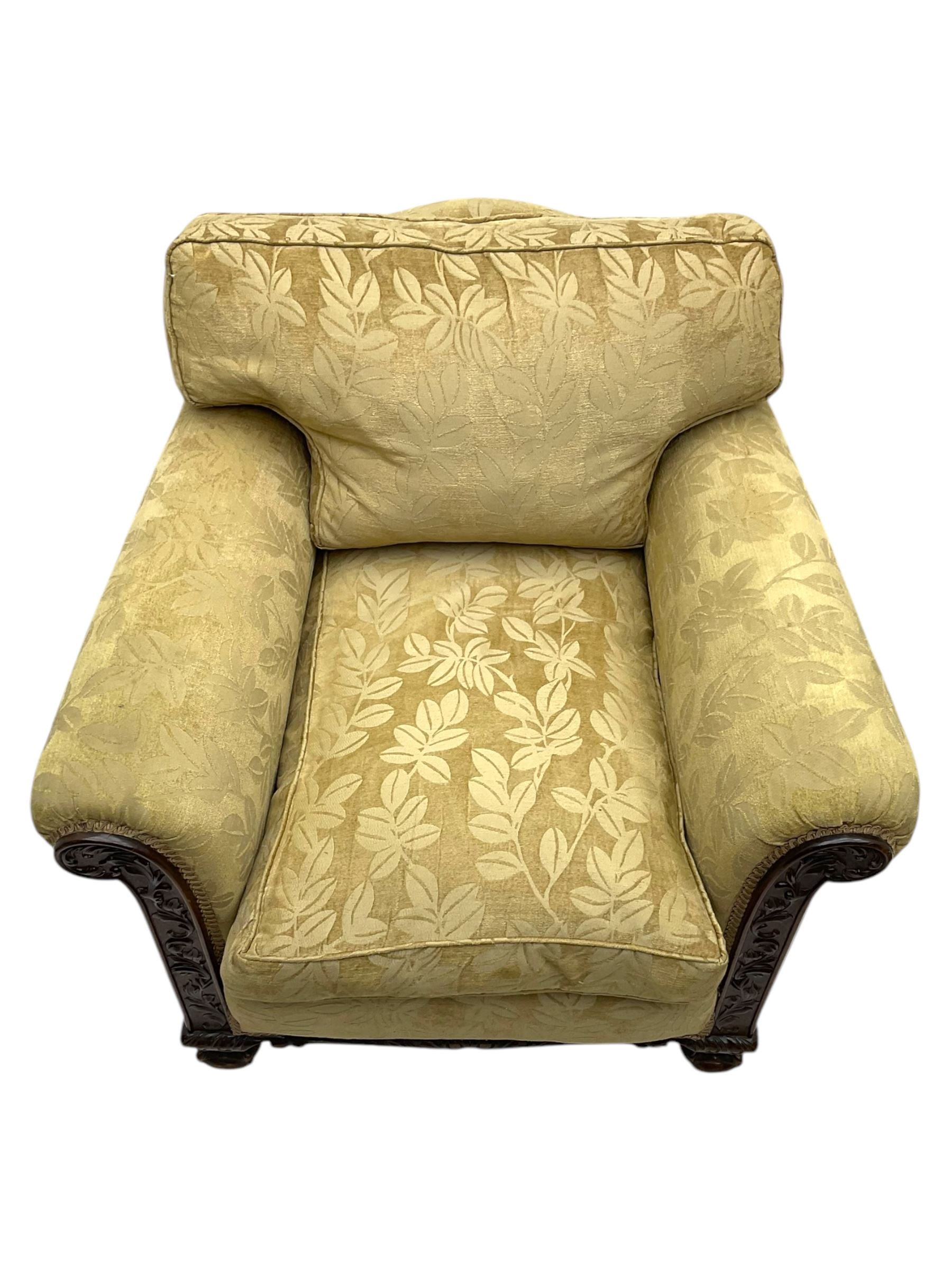 Early 20th century mahogany framed three-piece lounge suite - three-seat camelback sofa (W203cm, D105cm); pair of matching armchairs (W95cm, D96cm); upholstered in neutral foliate pattern fabric, carved with trailing leafy branches, ball and claw carved feet with brass castors 
