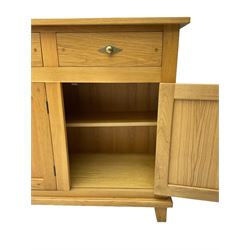Light oak sideboard, rectangular top, fitted with three drawers and three panelled cupboards, on square feet