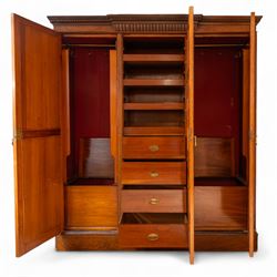 Late Victorian oak and burr oak three-section mirror wardrobe, central door with three carved panels with shell and acanthus decoration, fitted with four drawers and four tray drawers, linen sides with bevelled mirrored panel doors with hanging space, plinth base, and dental cornice