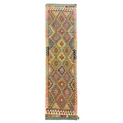 Tibetan-design handwoven rug, deep red field with three central medallions in yellow and blue, traditional yellow key border, white fringes on both ends