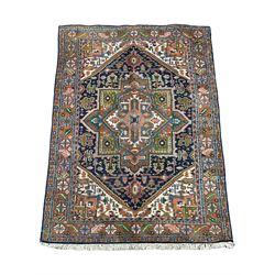 Persian Heriz indigo and rust ground rug, central geometric star medallion decorated with stylised foliate motifs, the border decorated with stylised flower heads