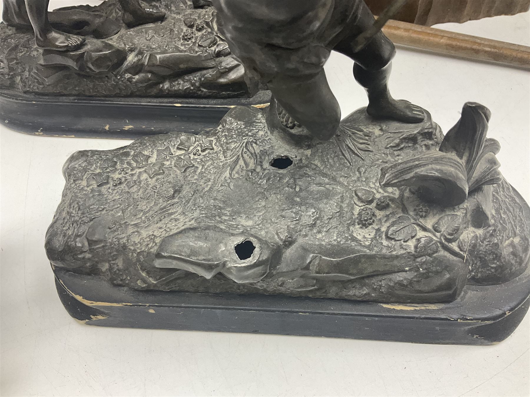 Spanish carved figure of Don Quixote, holding a book, base stamped 'Ouro, together with two spelter figures and one other