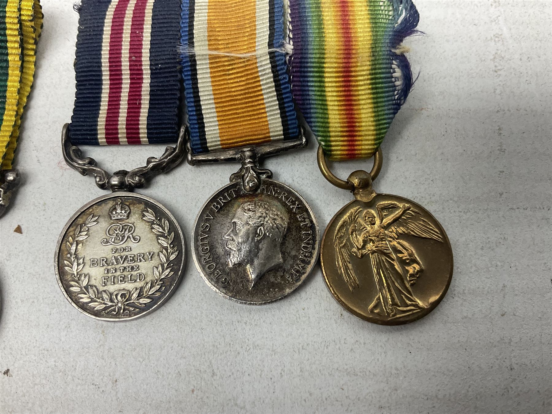 George V Military Medal and Distinguished Conduct Medal miniature group of seven medals comprising MM, DCM, WW1 trio including 1914 Star with date clasp and MID leaves, The Great Durbar Delhi 1911 Medal and LSGC; on pinned wearing bar; WW1 Military Medal miniature group of three comprising MM, BWM and Victory; Victoria North West Canada 1885 miniature; and George VI miniature Territorial Efficiency medal; all with ribbons