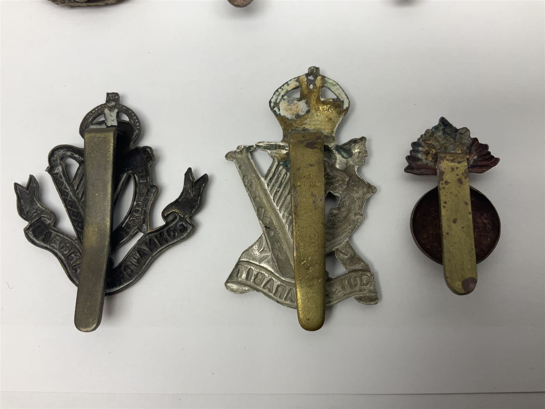 Fourteen cap badges of Irish interest including Royal Dublin Fusiliers inscribed to the slider 'From A. O'Connor 2nd Batt. Dec.2nd 1915', Connaught Rangers, South irish Horse Yeomanry, Inniskilling Fusiliers, Royal Irish Regiment etc; and seven Welsh badges including South Wales Borderers, Welsh Guards, 3rd Bn. Monmouthshire Regt. etc (21)