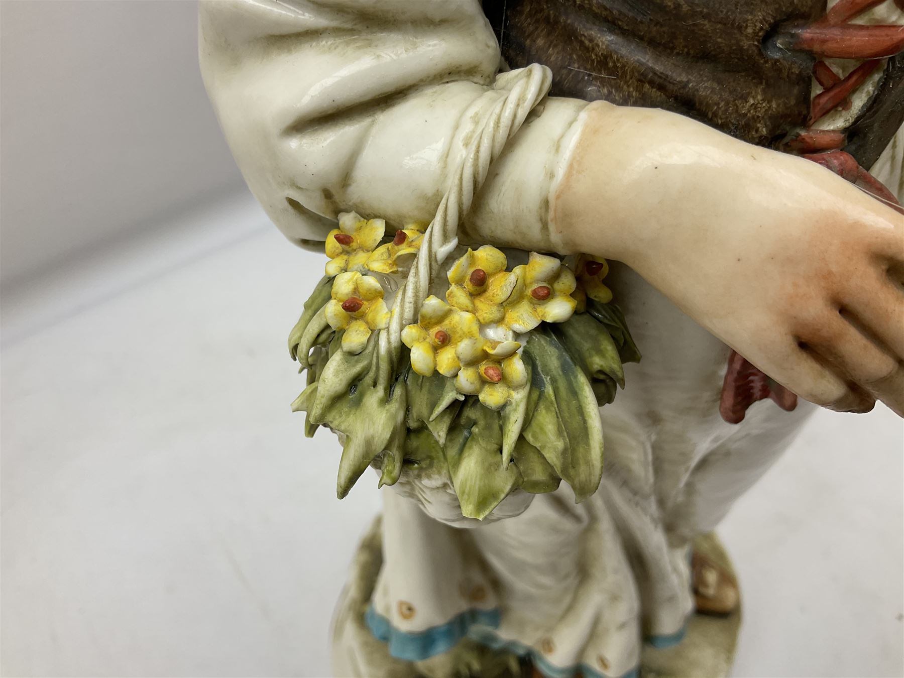 Pair of Capodimonte table lamps, in the form of cherubs holding a brass fitting, together with a pair of large Capodimonte figures in the form or a man and woman resting up on tree stump, largest example H57cm