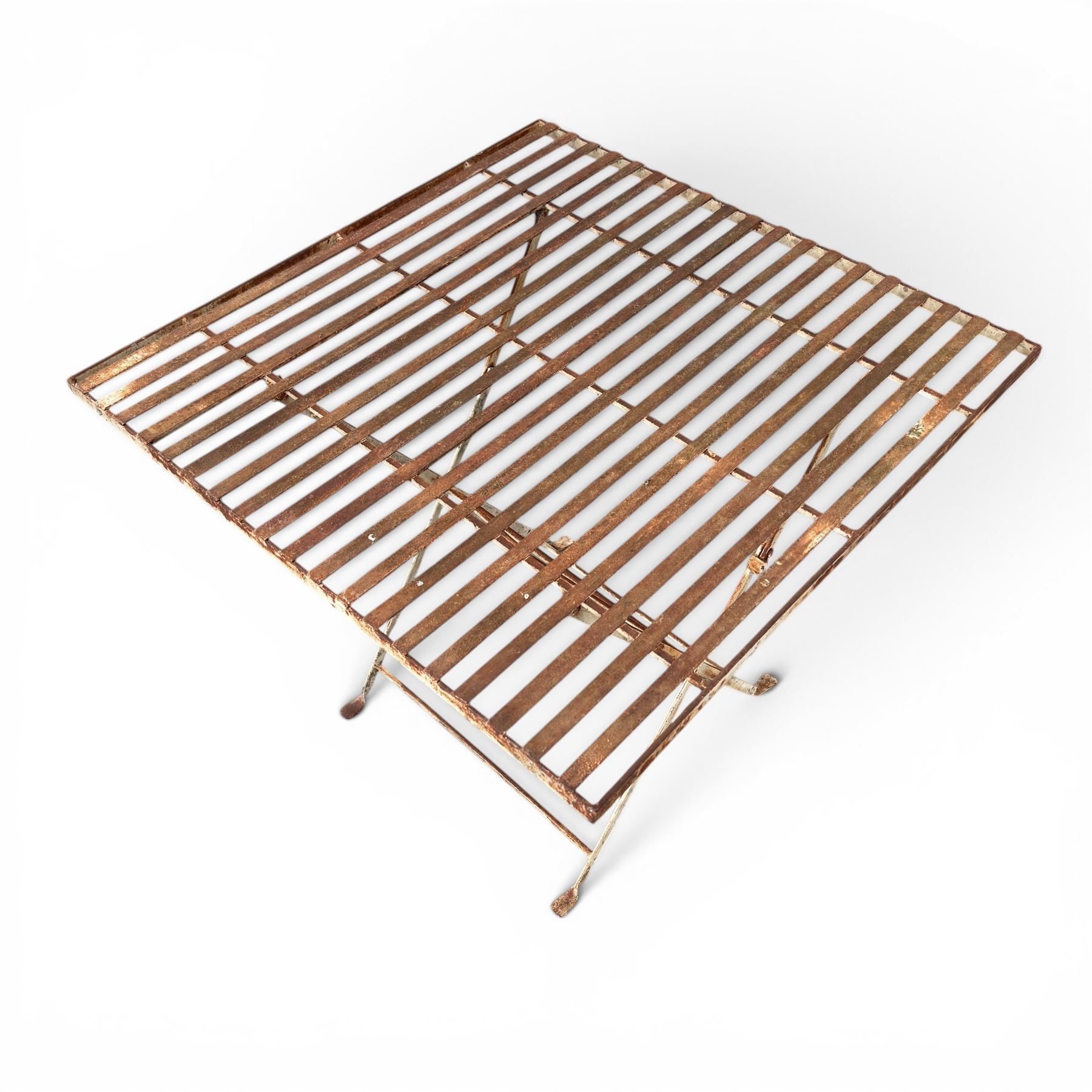 Pair of French 1920's wrought metal folding bistro café tables, the strapwork top over a folding X-frame base, in rustic white painted finish