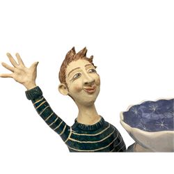 Ceramic 'girl and boy dish', by Helen Kemp, an oval dish with a mottled pink ground and gilt edging upon the sculpted heads of a girl and a boy, together with a 'boy sconce', by Helen Kemp, a sculpted boy holding a small bowl with foliate decoration, both with the artist's mark beneath.