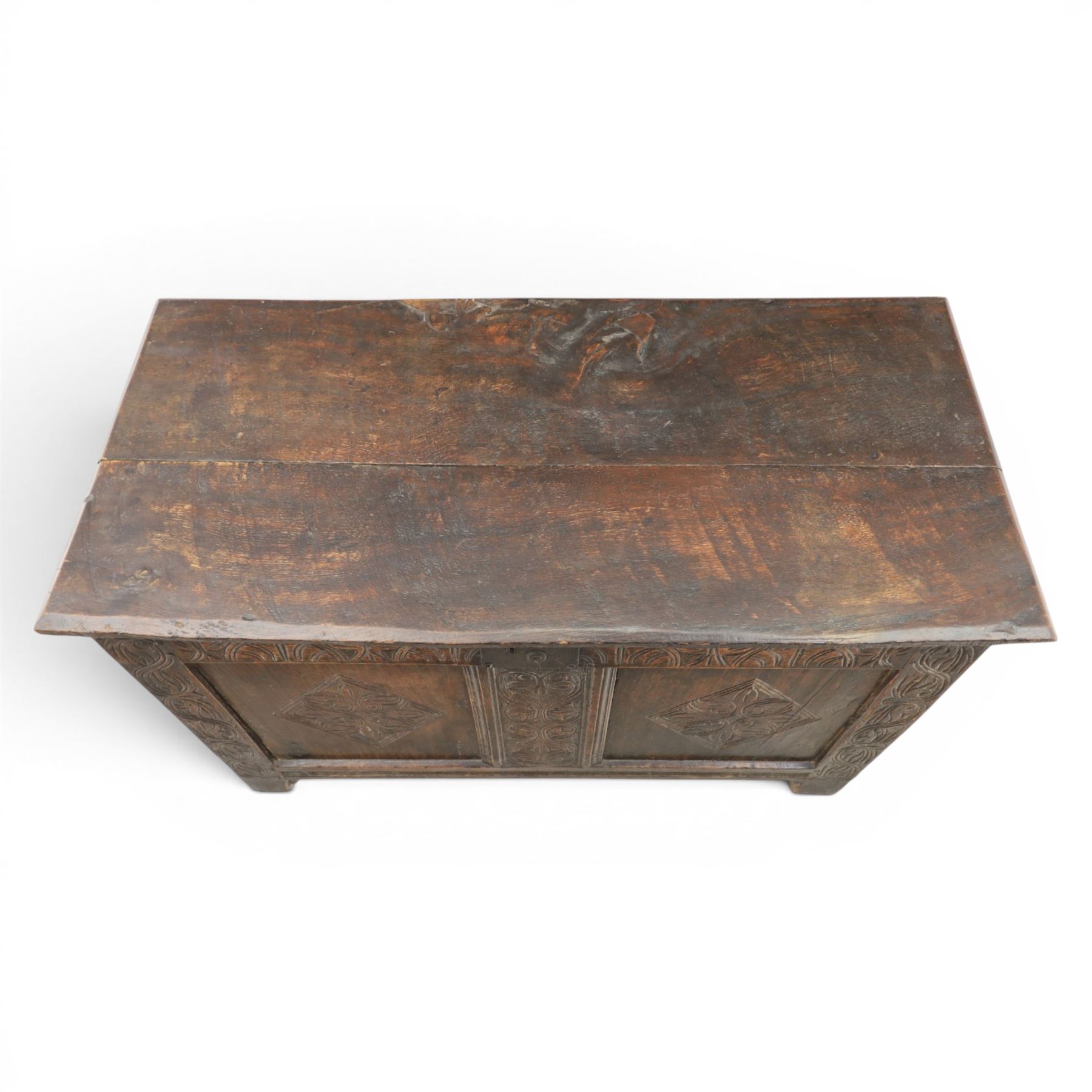 18th century oak coffer with carved frieze and rails, rectangular plank top with iron strap hinges, raised on stile supports