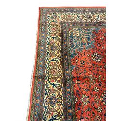 Persian Mahal carpet, red ground field with scrolling interlaced foliate and central medallion, decorated all over with stylised flower and plant motifs, seven band border, the main band ivory ground with scrolling floral design 