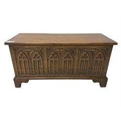 Mid-20th century oak blanket box, hinged lid over front carved with Gothic tracery work and flower heads, on bracket feet