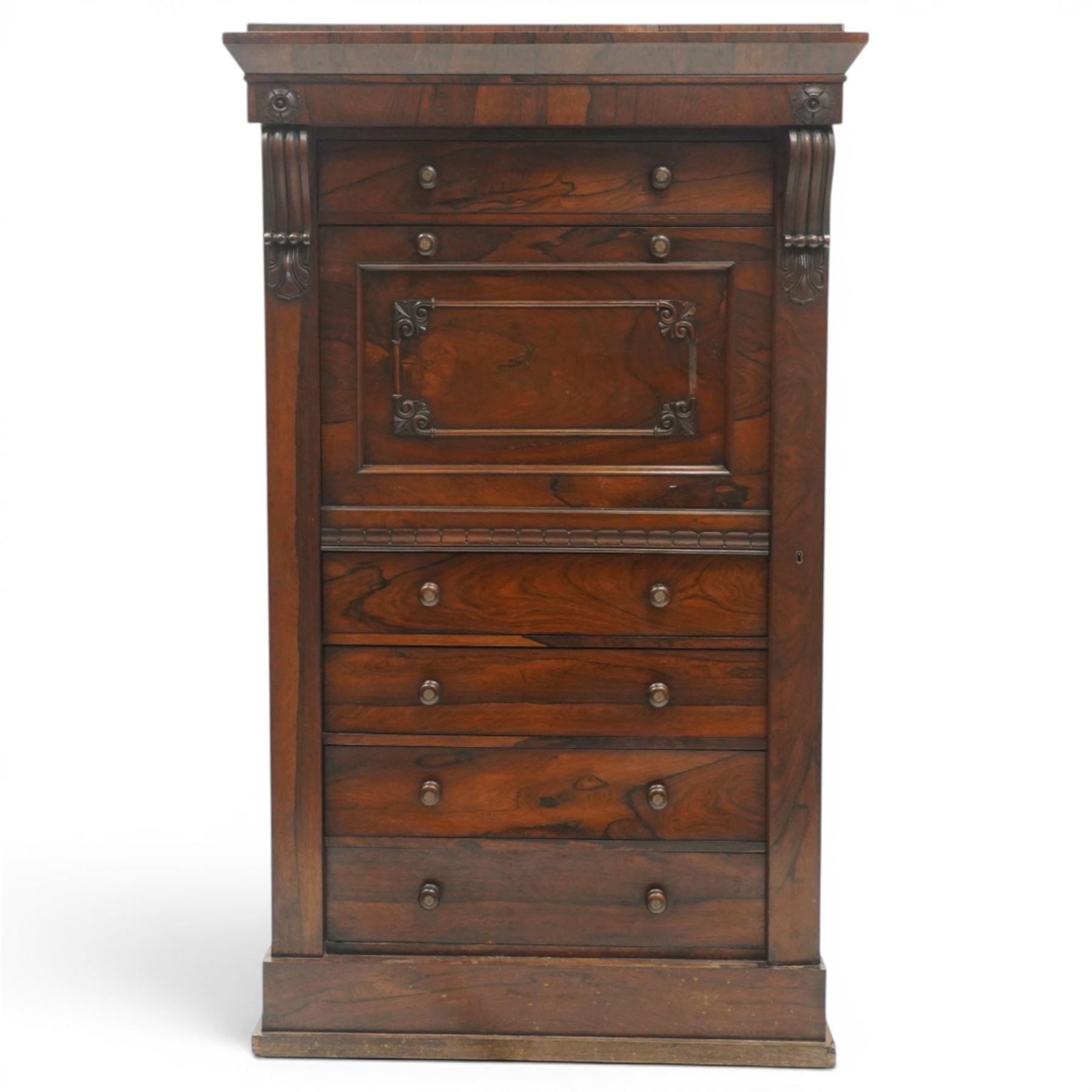 Victorian rosewood Wellington secretaire chest, the projecting stepped cornice over a banded frieze with moulded rosette mounts, single drawer over a secretaire fall-front opening to reveal a maple lined interior with assorted pigeonholes and correspondence drawers, over a lappet carved lower edge with four graduating drawers below, each with turned pull handles, flanked by hinged lock to the right and plain stile to the left surmounted by reeded corbels, raised on a skirted base