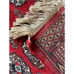Tekke Bokhara red ground rug, decorated with two rows on Gul motifs, geometric design borders decorated with stylised floral motifs 