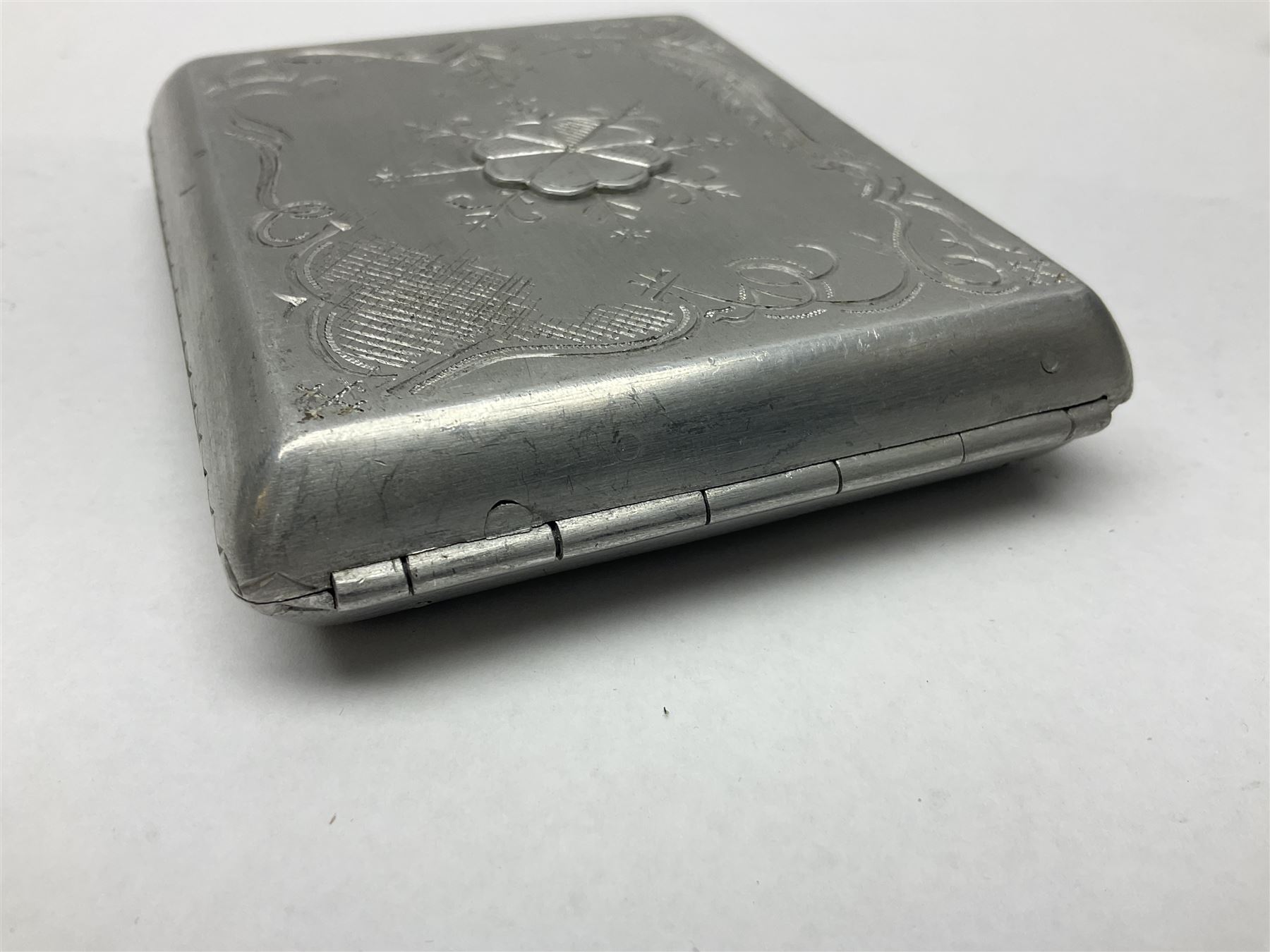 Aluminium cigarette case, by repute made from the R.38. Airship wrecked over Hull August 24th 1921, together with a aluminium matchbox cover, the front inscribed 'R38 WRECKED AT HULL 24 AUG 1921 44 LIVES LOST', the event illustrated verso, (2)