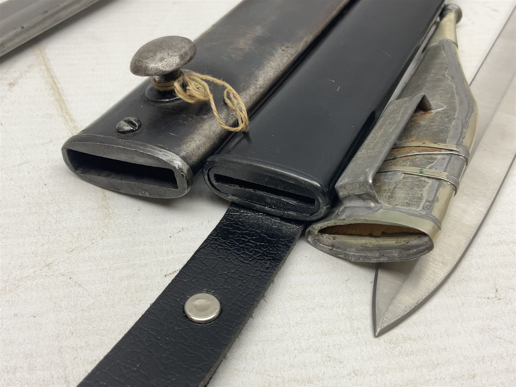 Spanish Model 1941 Bolo bayonet the 24cm steel blade marked 'NF Toledo 4992 H'; in steel scabbard marked '5828 F' L39.5cm overall; Arabian Jambiya type knife with white metal covered grip and jewelled scabbard, inscribed script to blade; and replica WW2 German dagger/knife in scabbard (3)