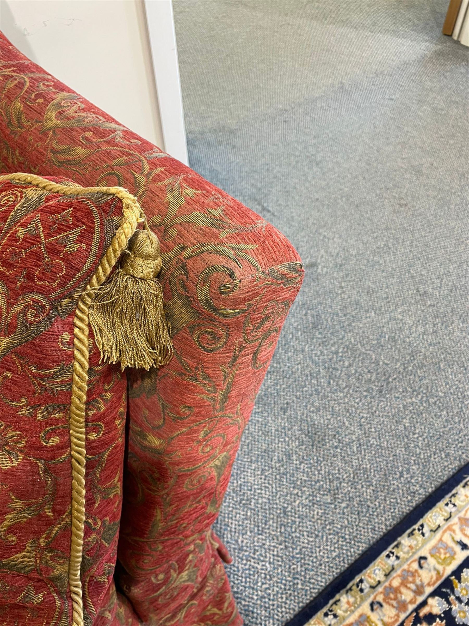 Large Knole design hardwood-framed three-seat drop-arm sofa, upholstered in crimson fabric decorated with trailing acanthus leaves and shields, together with scatter cushions 