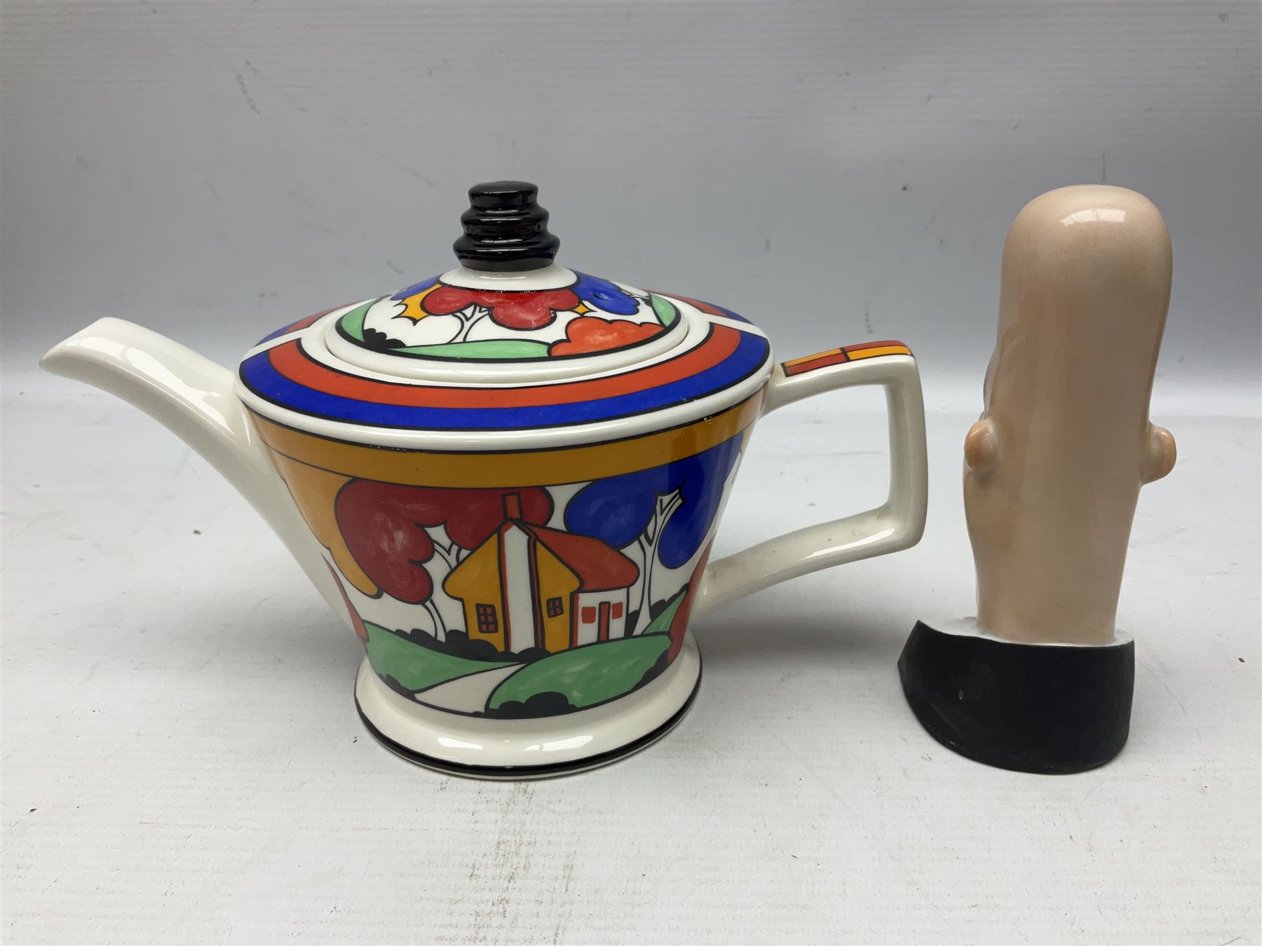 Novelty ashtray modelled as bald headed singer, the base entitled `By the light of the silvery moon...' together with a Sadler teapot of Clarice Cliff Farmhouse pattern style