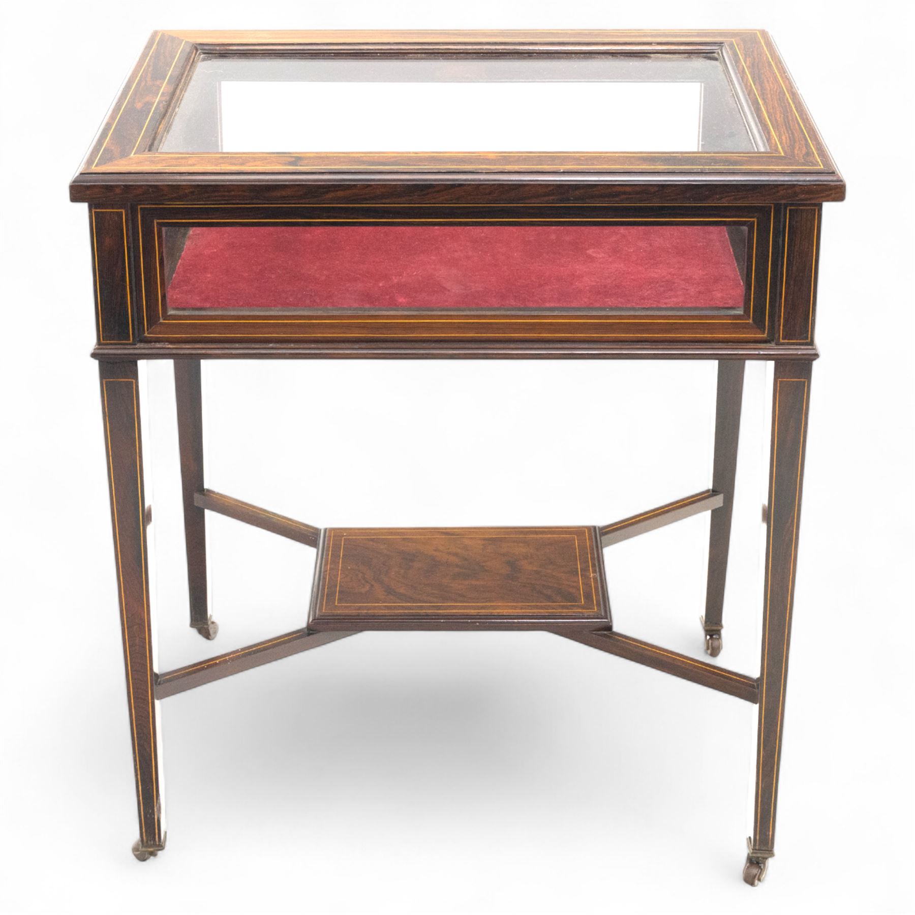 Edwardian rosewood bijouterie cabinet, the hinged rectangular top with line inlay enclosing a velvet lined interior, upon slender tapering legs inlaid with satinwood foliate marquetry decoration, with stretchers united by an under tier, raised on castors 