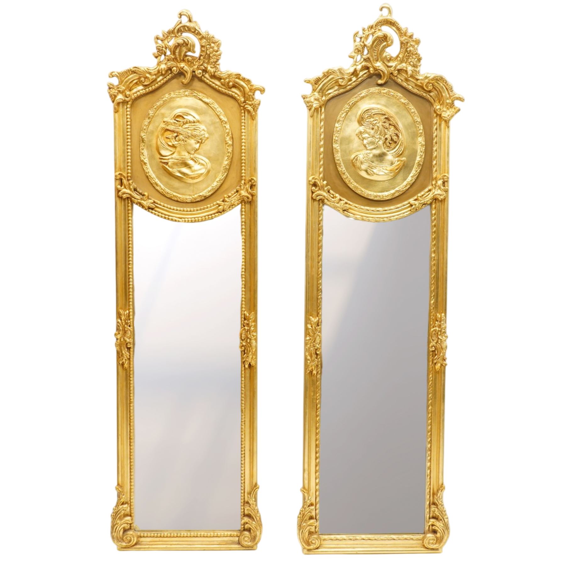 Pair of Rococo Revival gilt framed wall mirrors, the pierced scrolling rocaille pediment with foliate motifs over an oval panel with relief portraits of classically draped females, over a shaped rectangular bevelled plate surrounded by beading and scrolling foliate motifs