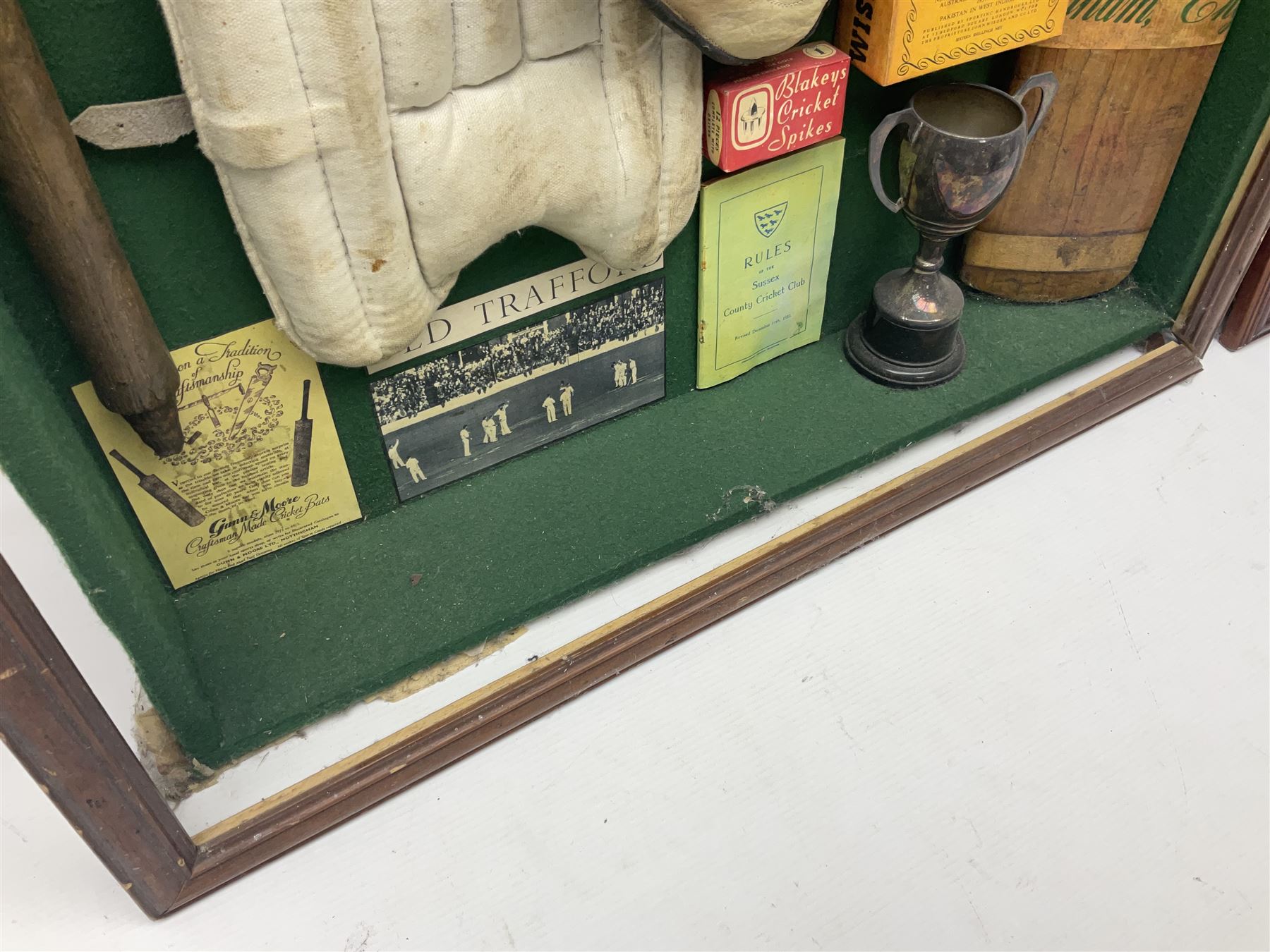 Four framed sporting memorabilia displays, the largest example containing 1930s cricket memorabilia, together with two fishing displays and a football display, each within wooden glazed frames, largest H105cm