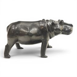 African carved hardwood ebonised figures of a rhinoceros and hippopotamus, each with stylised incised detail and polished dark finish, largest H 61cm, W 91cm)