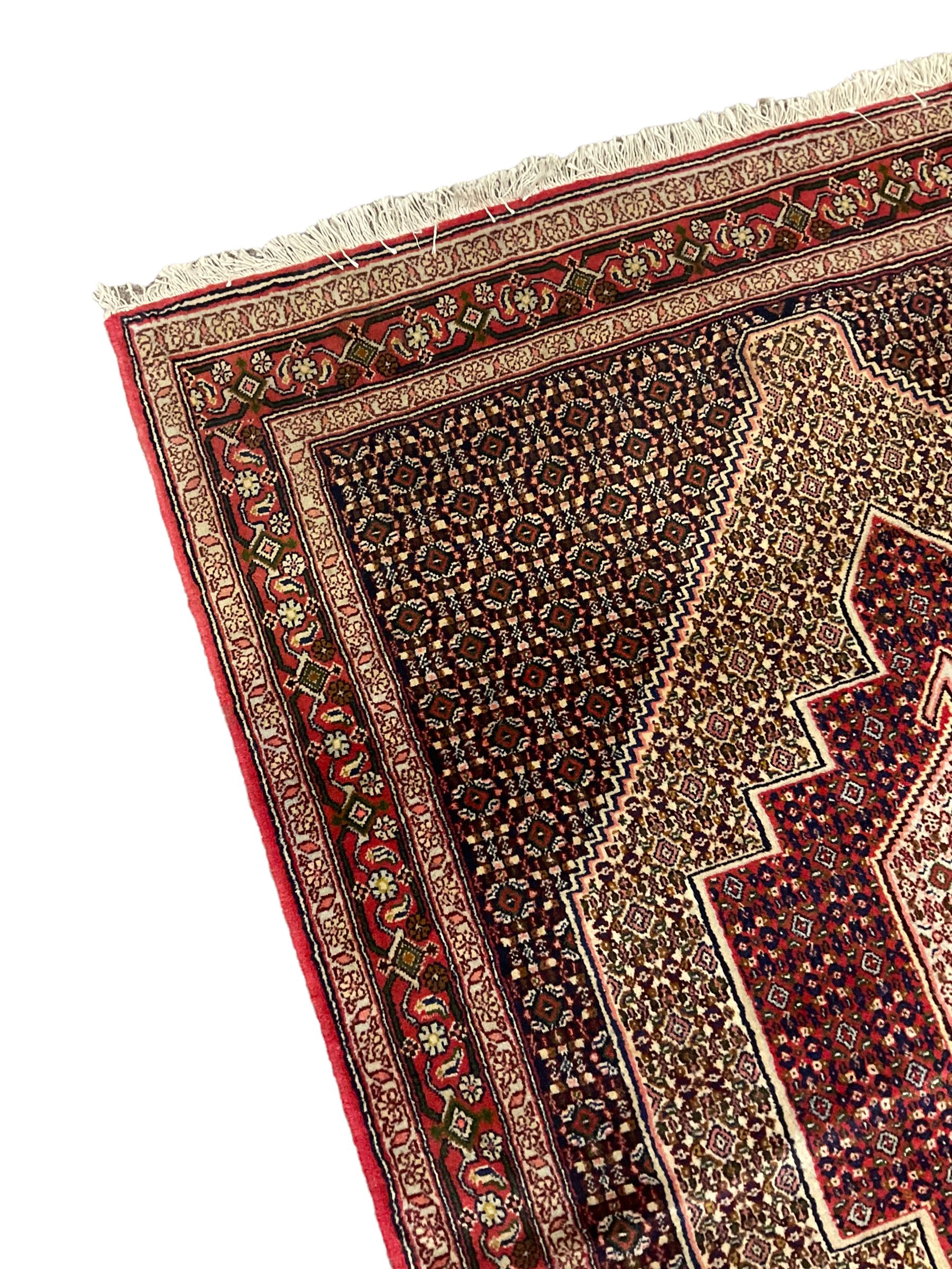 Persian Hamadan rug, lozenge field and decorated with repeating Herati motifs, the band border with repeating design decorated with stylised plant motifs
