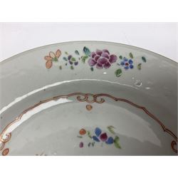 Three 18th century Chinese Famille Rose plates, the first example enamelled with blossoming peonies, rockwork and fence, the other two examples of similar design, decorated with blossoming peonies and sprigs within shaped inner borders, each approximately D23cm