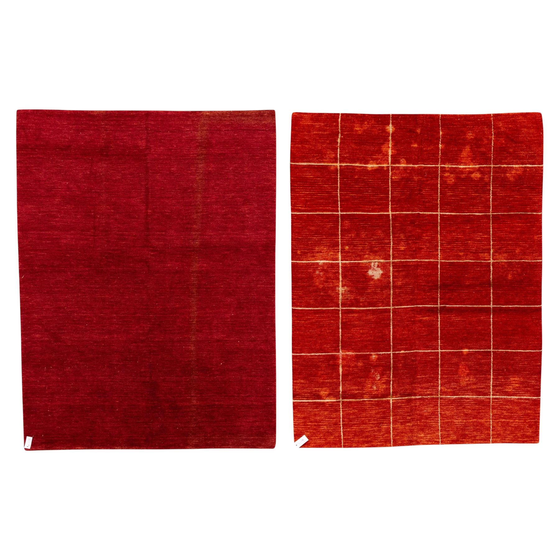 Two contemporary Moroccan Berber hand-woven rugs, deep madder red field of plain design, 199x153cm, other with deep madder red field with a simple lattice of ivory lines forming panels with some tonal variation, 190x146cm 