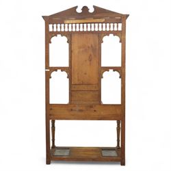 Edwardian walnut hall stand, the shaped pediment above turned spindle gallery and bevelled mirror, fitted with brass double coat hooks, single drawer with cast handle and carved frieze, flanked by turned supports, lower platform fitted with twin metal drip trays