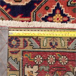 North West Persian carpet, the indigo field centred by a large terracotta and ivory medallion with matching pendants, decorated throughout with stylised palmettes, flowerheads and branching foliage, ivory geometric floral spandrels, enclosed by a red palmette border and narrow patterned guard bands