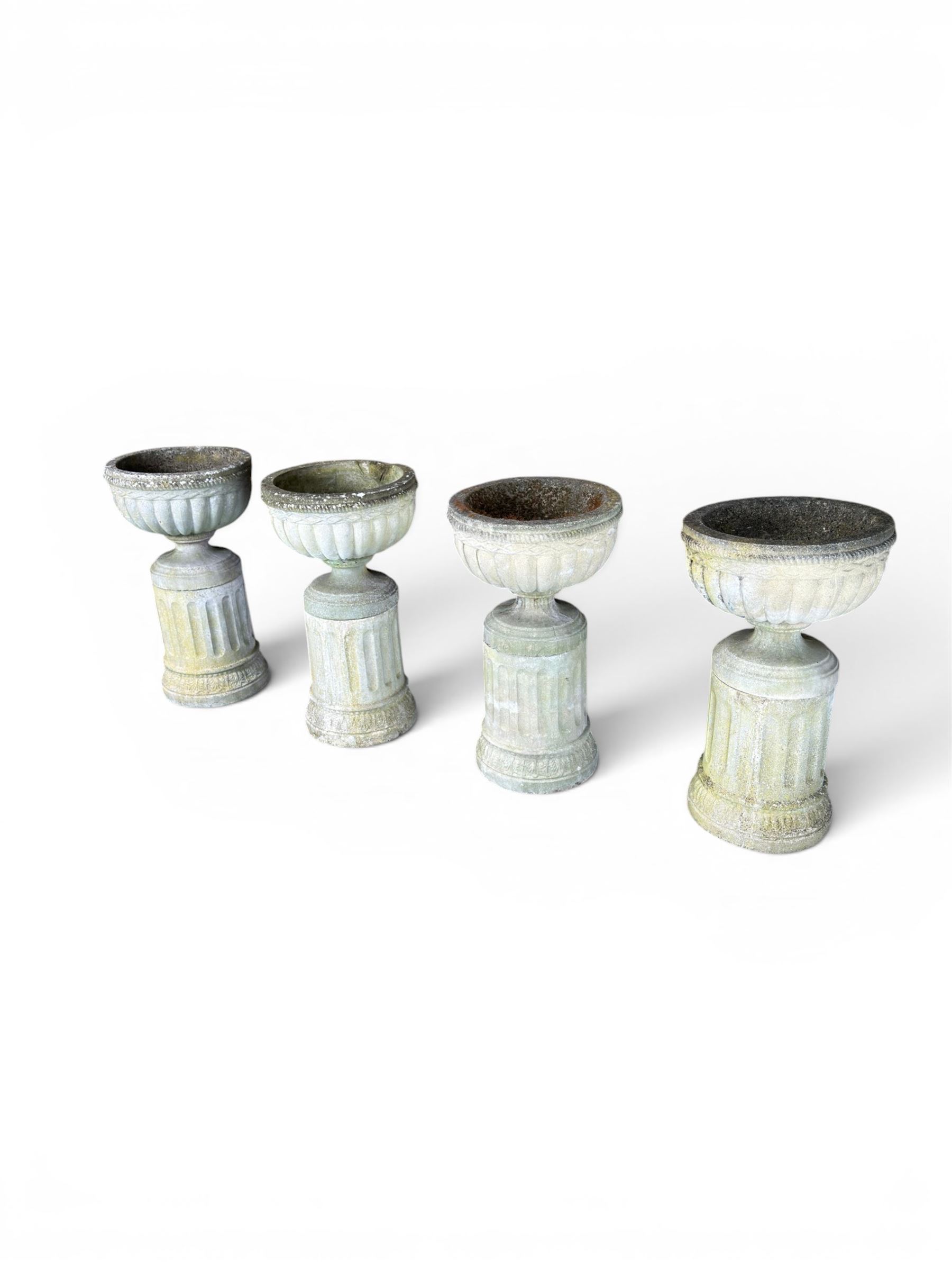 Four 20th century good quality weathered cast stone pedestal urns, circular lobed bowls with rope twist and lattice border, raised on squat base with fluted columns