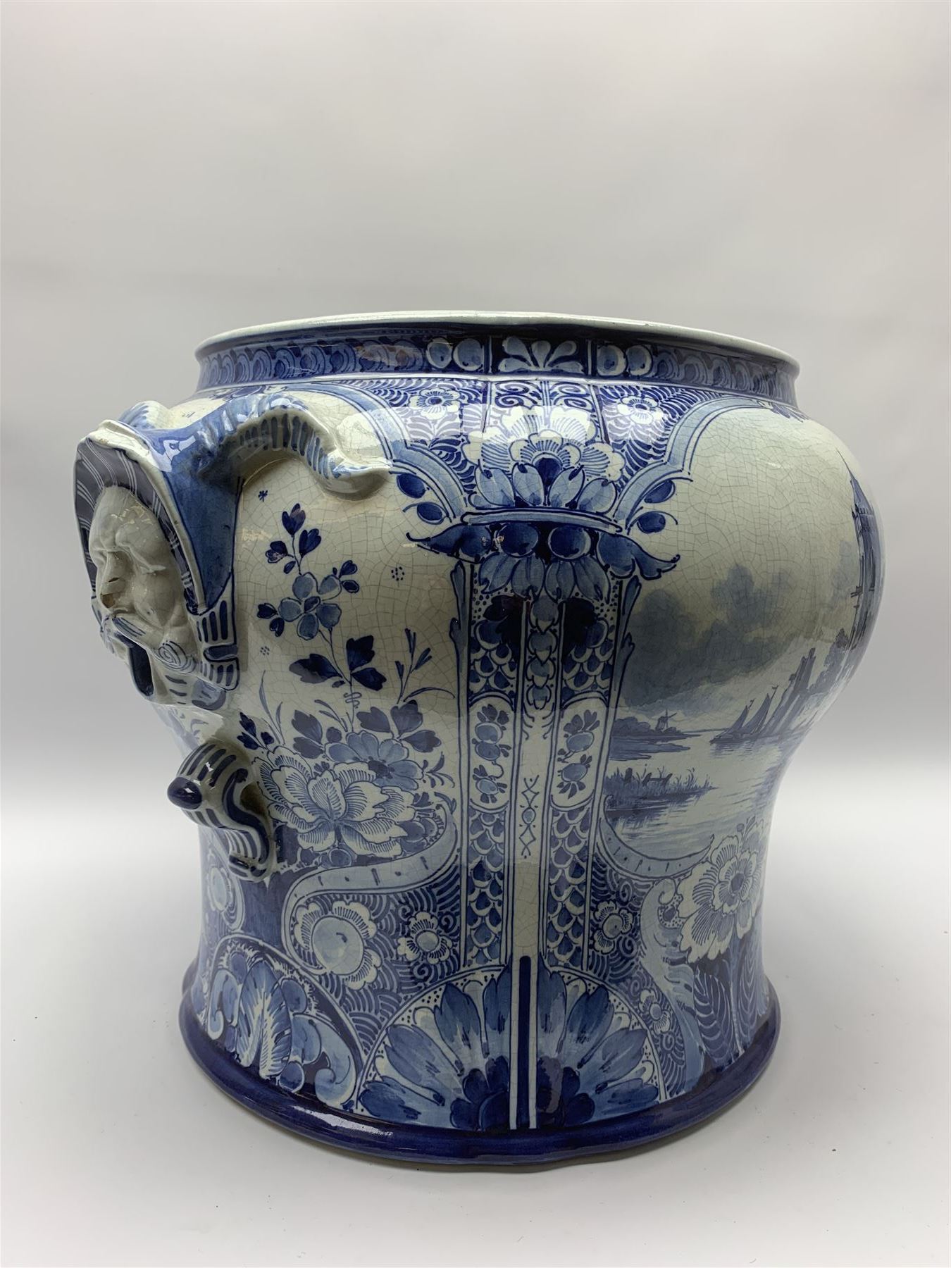 Large 20th century Delft blue and white jardinière, of baluster form with twin zoomorphic mask lug handles, decorated with hand painted panels of waterside scenes, within foliate surround, impressed and painted marks beneath for De Porceleyne Fles workshop, Delft, H35cm, rim D32