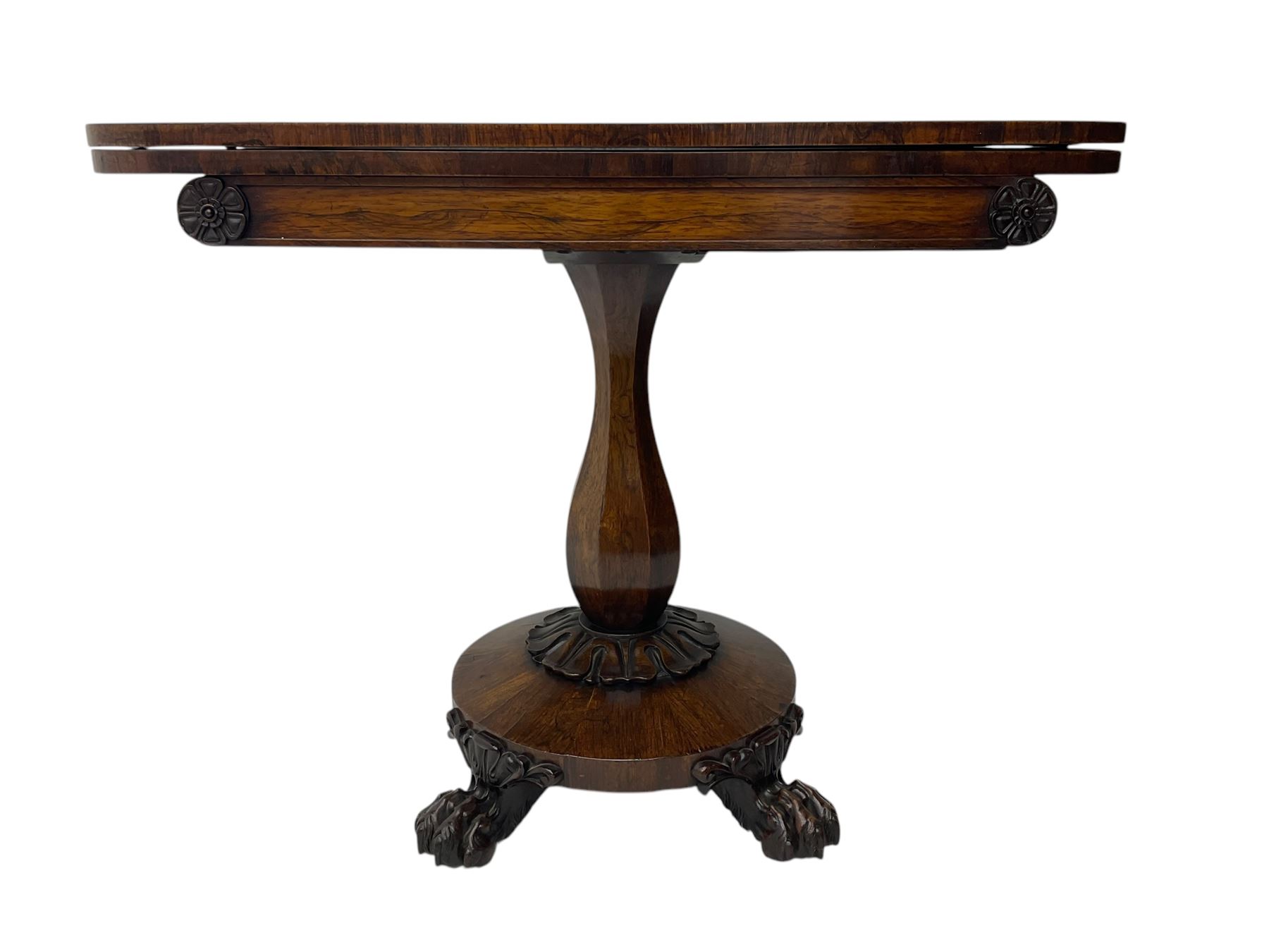 Victorian mahogany tea table, rectangular top with rounded corners, folding and swivelling to reveal interior surface, supported on a faceted baluster-shaped column, raised on a circular platform base with carved acanthus details, ending in four lion paw feet