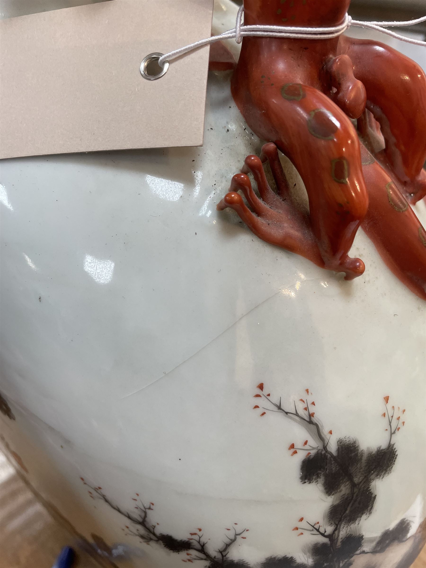 Chinese Republic period porcelain moon flask vase, of typical compressed spherical form, the neck and shoulders with applied iron red dragon handles, the body decorated in iron-red and grisaille with a 'one hundred children' design, depicting various children at play and engaged in musical pursuits within a garden setting, with apocryphal Qianlong mark beneath, H47cm