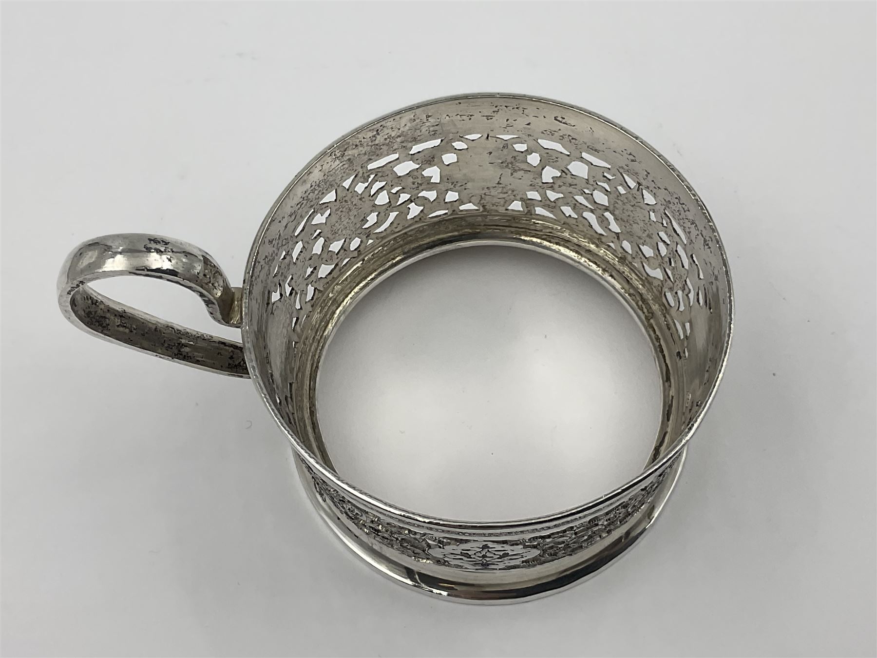 Early/mid 20th century Persian silver tea service, comprising circular serving tray, teapot, twin handled sucrier and cover, milk jug, five tea glasses with six silver holders, six tea spoons, and pair of sugar tongs, each profusely chased with foliate arabesque decoration, each bearing marks including 84 for 840 fineness, tray D40cm, teapot H16cm