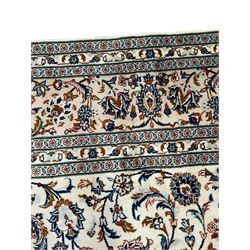 Persian Kashan ivory ground rug, decorated with curled leafy branches and palmettes, the border with scrolling design decorated with further palmettes, within floral pattern guard stripes