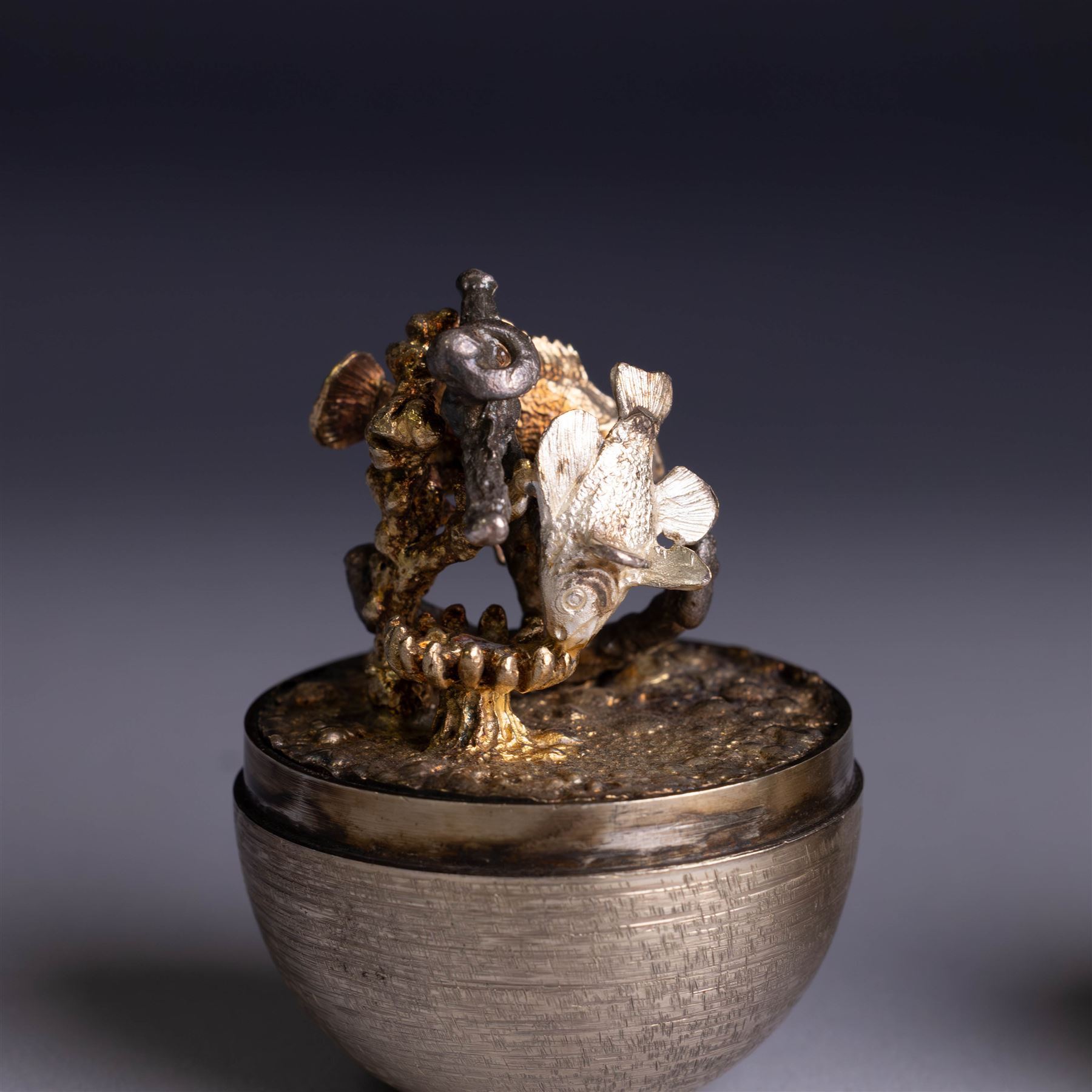 Stuart Devlin - Late 20th century silver and silver-gilt surprise egg, the textured gilt exterior opening to reveal an underwater scene with two fish and an anchor, hallmarked Stuart Devlin, London 1977, boxed, H10cm