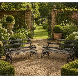 Coalbrookdale - rare pair of wrought iron and slatted wood garden benches, the twin wrought iron strapwork bench-ends formed of four scrolls over splayed feet, number 77 in the Coalbrookdale Castings Catalogue (see illustration)