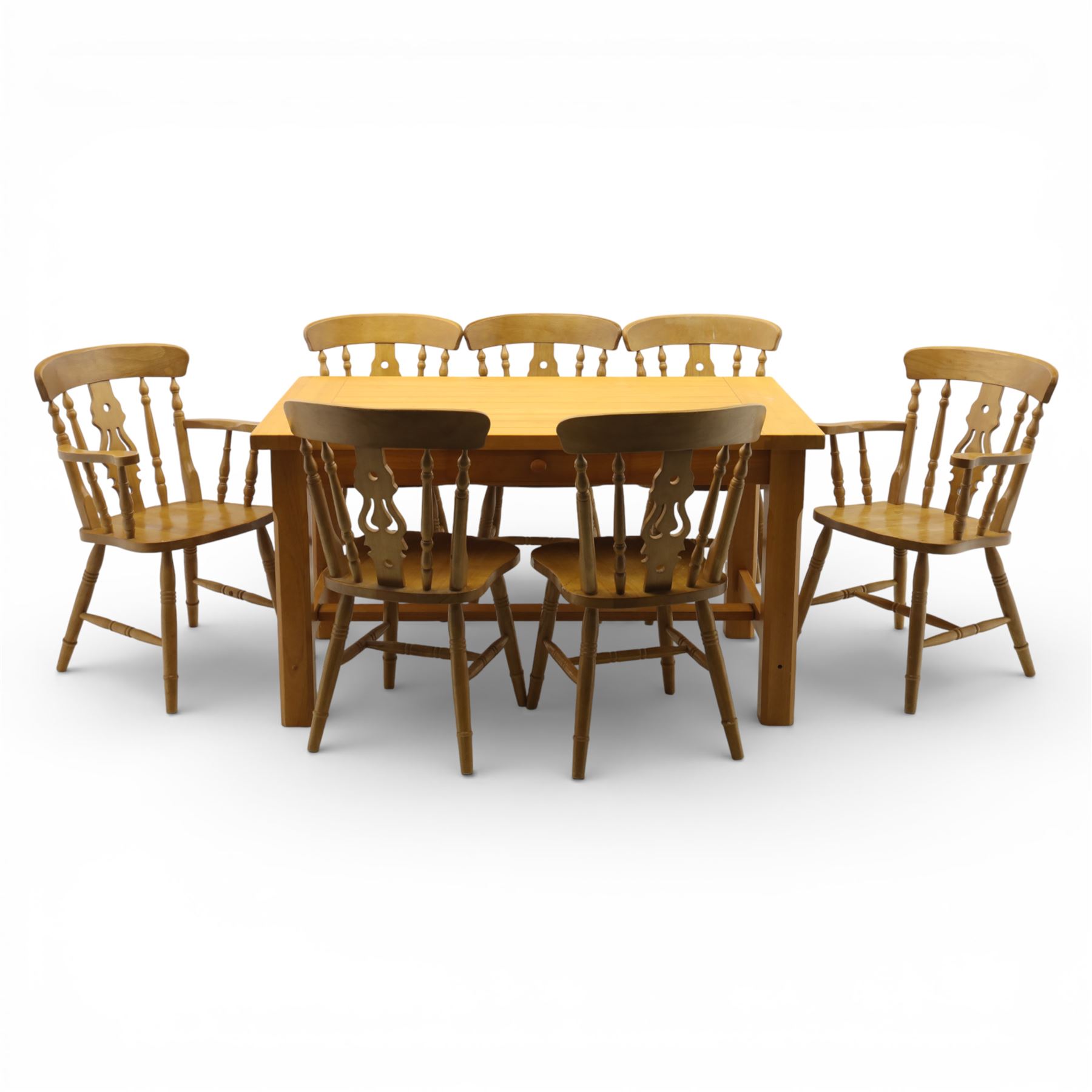 Solid oak dining table and set of seven pine farmhouse chairs including two carvers, rectangular top with tongue and groove style finish, supported a 'H' stretcher with square chamfered legs, pine farmhouse chairs with central splat and turned legs