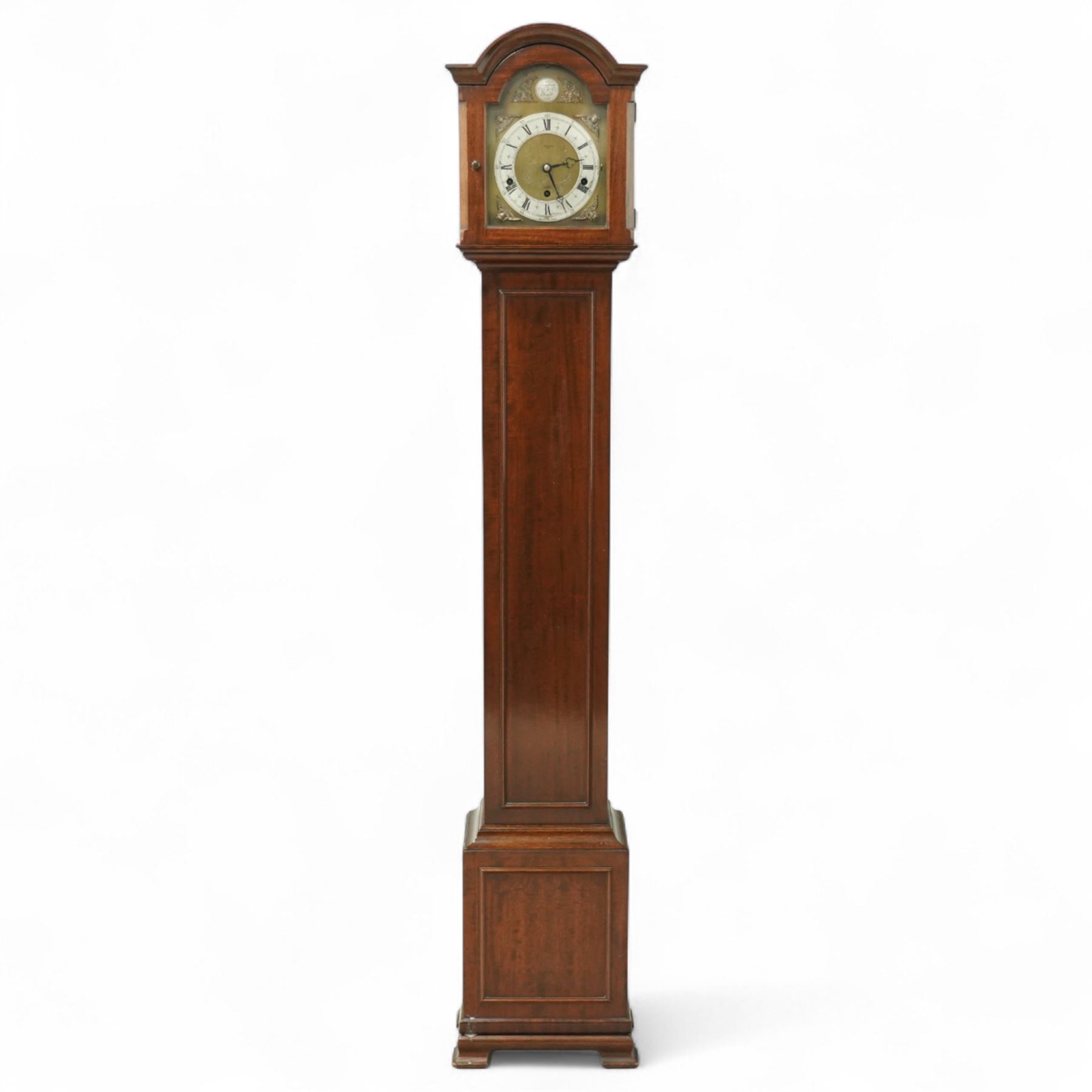 Carmichaels of Hull - mahogany cased 8-day musical grandmother clock c 1930 - with an arched pediment and arched hood, full-length trunk door on a short plinth raised on bracket feet, brass dial signed Tempus Fugit and Carmichaels of Hull with cast spandrels, matted dial centre and silvered chapter with Roman numerals, three train spring-driven movement chiming the quarters and hours on 8 gong rods with Westminster or Whittington chimes, movement stamped Elliott London with pendulum.