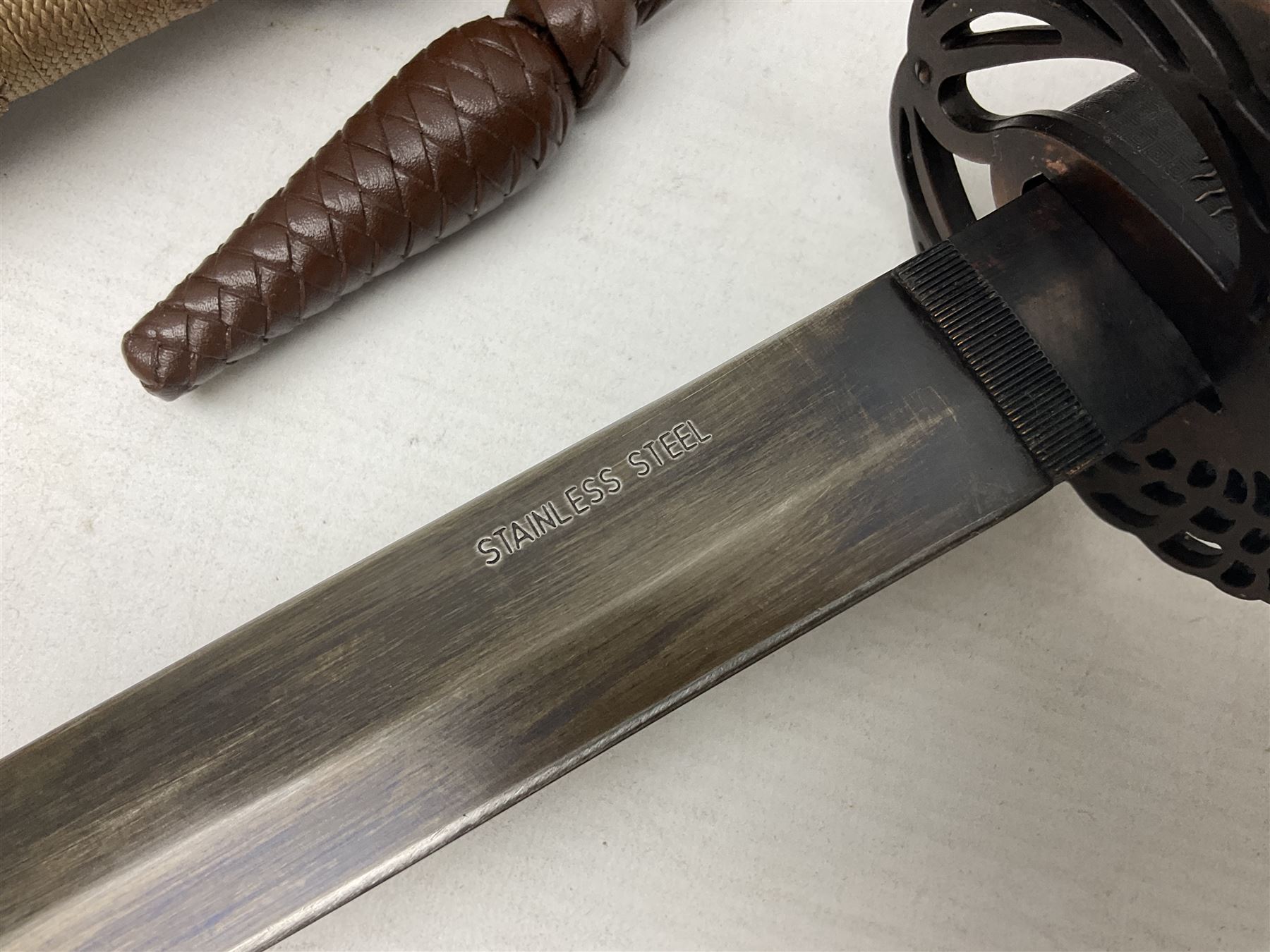 Reproduction Scottish officers basket hilt broad sword, the brass basket pierced with heart-shaped motifs lined with red lining, together with a reproduction Japanese Katana sword, longest L110cm