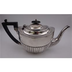 Early 20th century silver three piece tea service, comprising teapot, twin handled sucrier, and milk jug, each of oval part fluted form, the teapot with ebonised handle and finial, hallmarked Sheffield 1918, maker's mark WHM