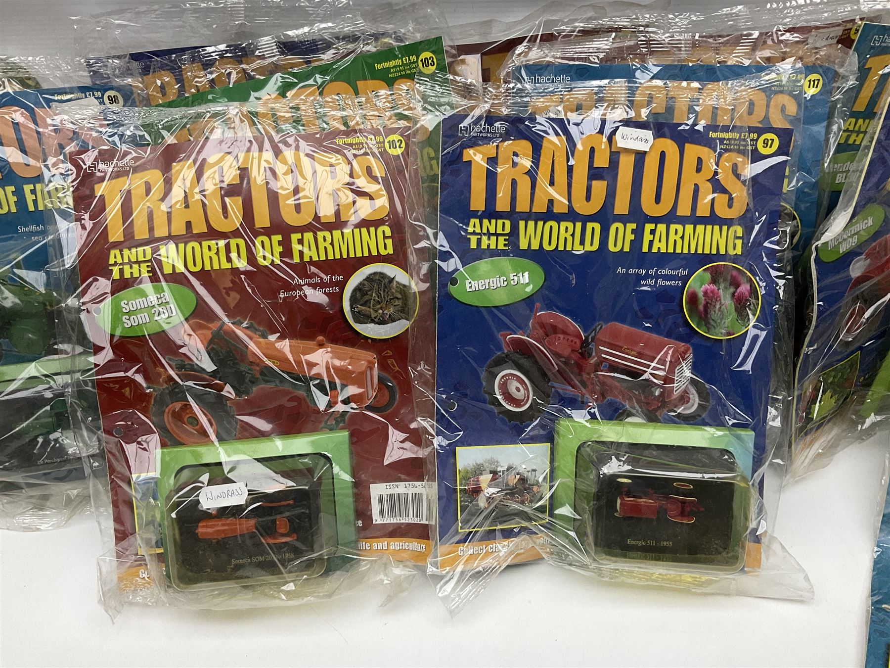 Eighteen issues of Tractors and The World of Farming magazine, together with sixty diecast tractors, all in original packaging, in three boxes 