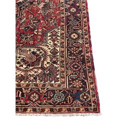 Persian Heriz red ground rug, large medallion decorated with palmettes and Ejder motifs, the border decorated with stylised plant motifs, within floral design guard stripes 