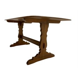 Ercol medium elm rectangular dining table, shaped end supports joined by stretcher, on sledge feet
