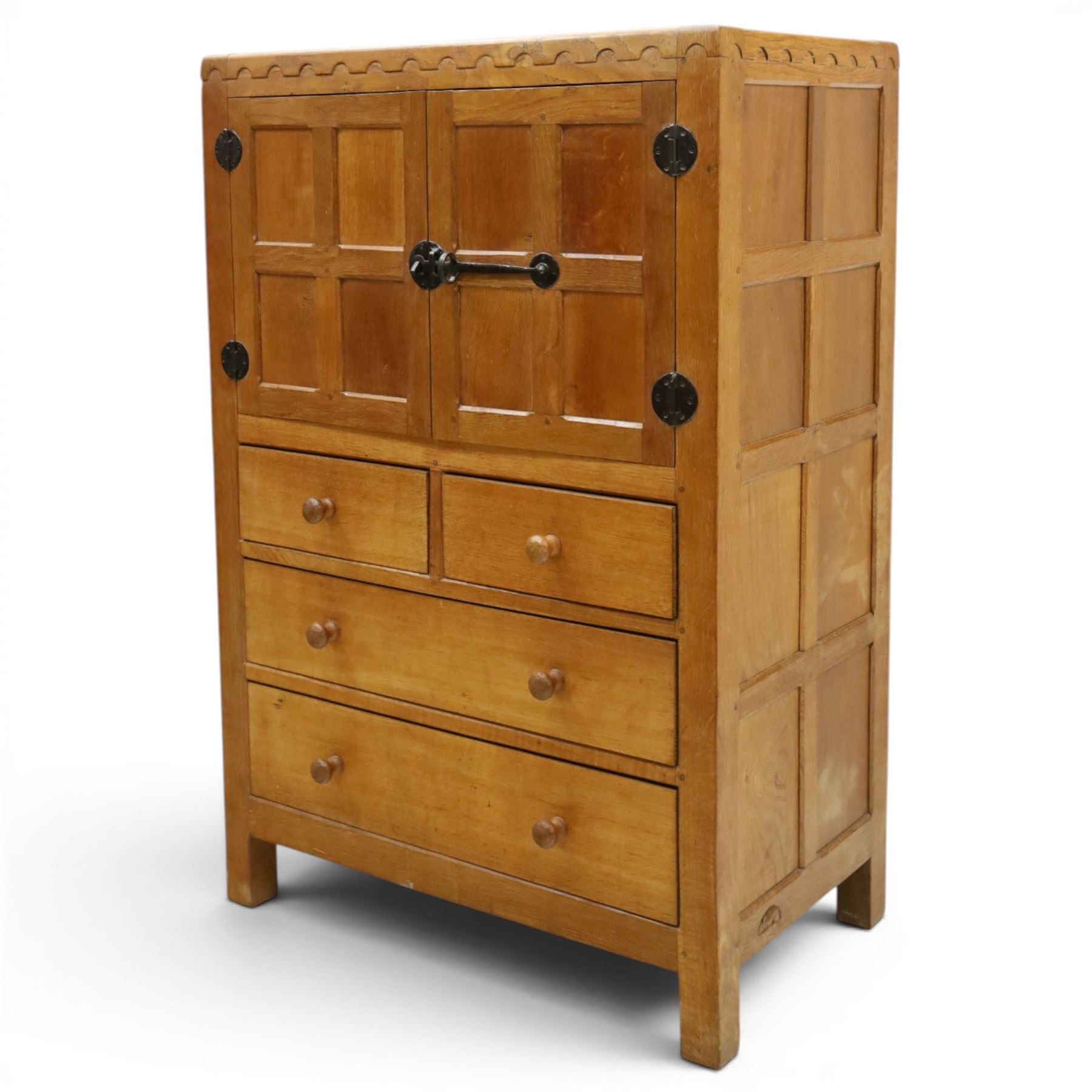 Mouseman - mid-20th century adzed and panelled oak tallboy chest, arcade carved cresting rail over two panelled cupboard doors with wrought iron fittings and latch, enclosing single shelf, over two short and two long drawers with lightly adzed facias and turned knob handles, raised on square supports, relief carved mouse signature, by the workshop of Robert Thompson of Kilburn