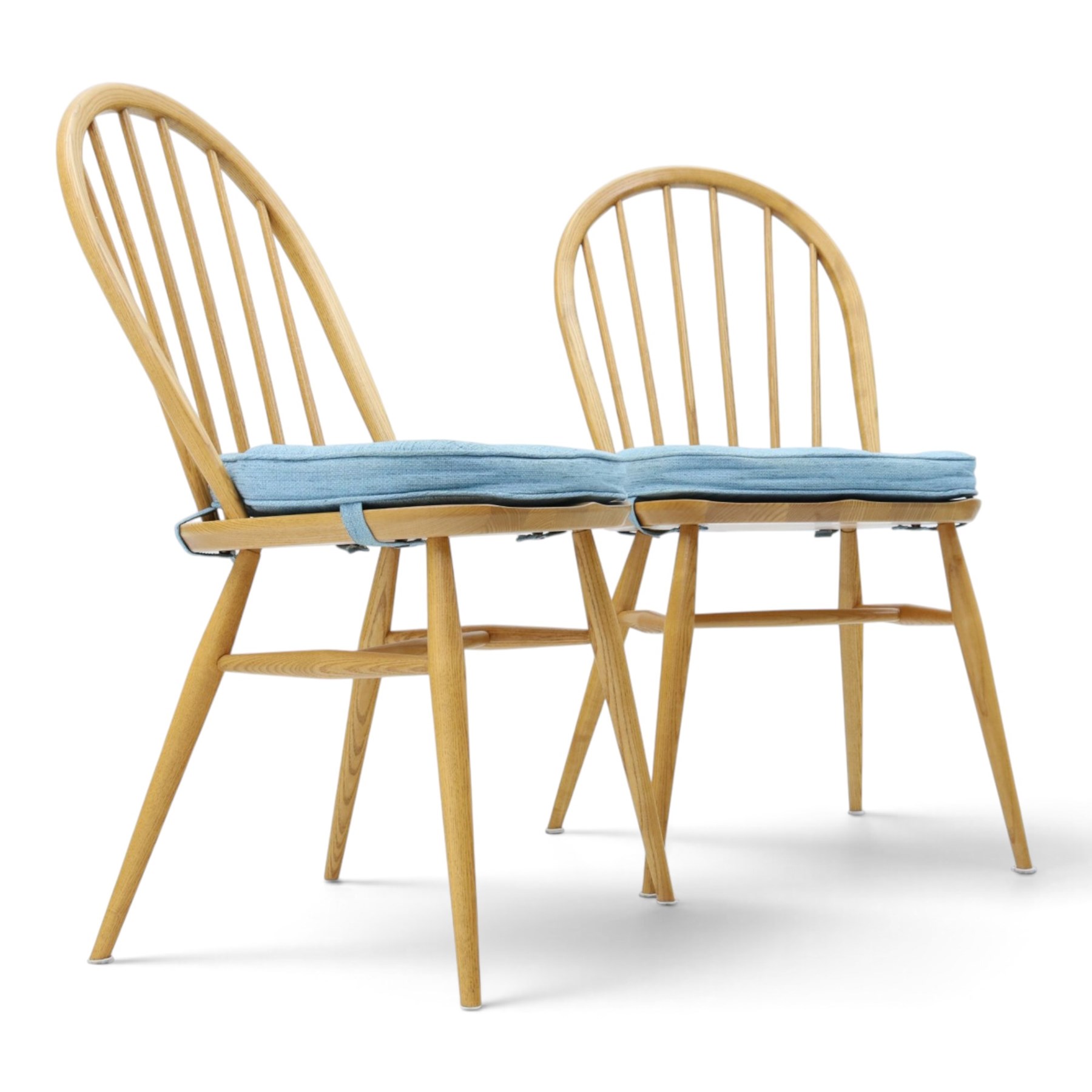 Ercol - pair of 'Windsor' dining chairs, with high hooped back, blue seat cushions with studded, tapered supports  
