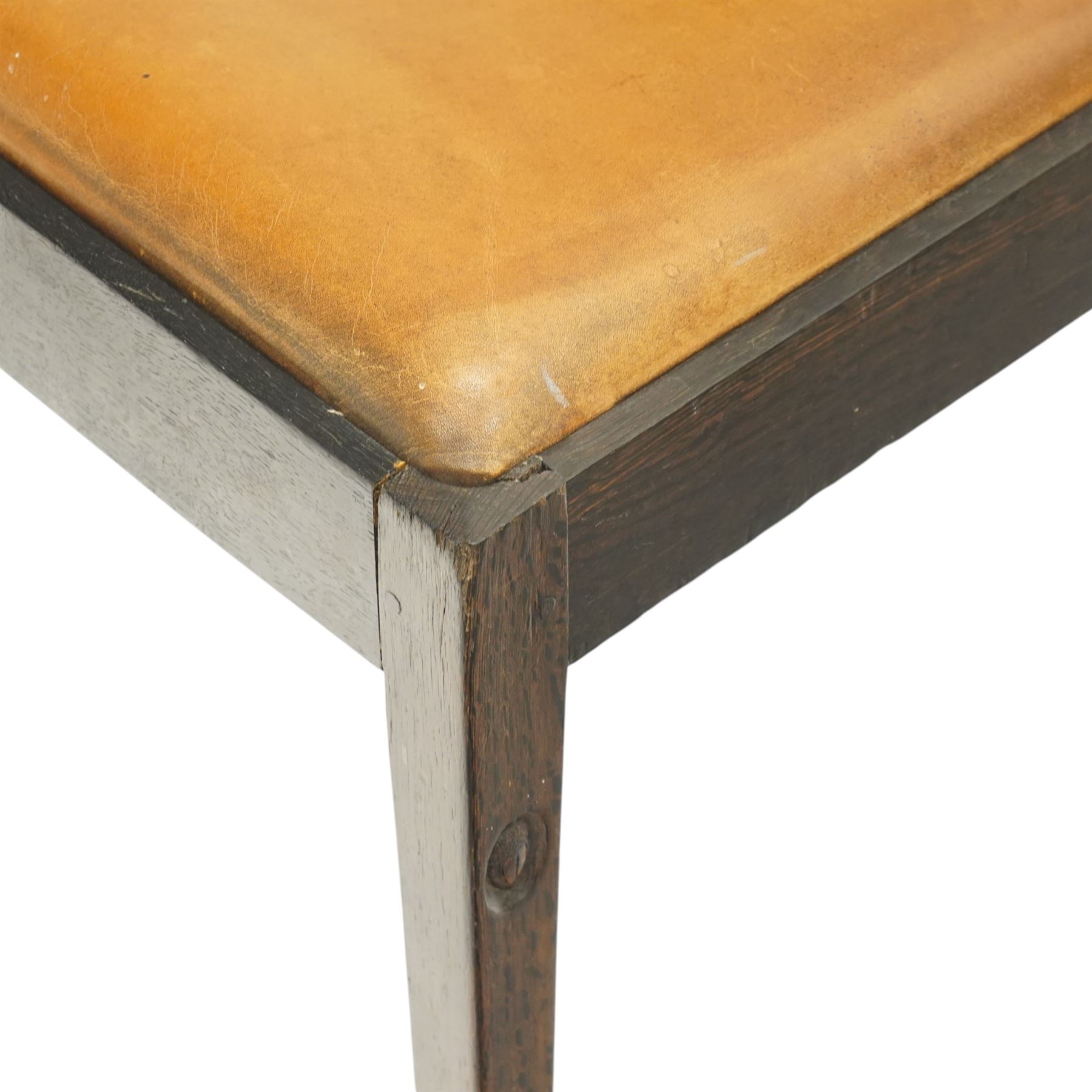 Acornman - set of four dark stained oak dining chairs, with four vertical slats, drop-in tan leather seat, supported on square tapering legs with carved acorn signature, by the workshop of Alan Grainger of Brandsby