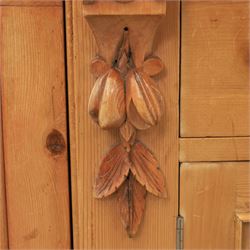 Victorian pine chiffonier, shaped moulded top with raised scroll carved back surmounted by carved fruit and foliate crest, fitted with two frieze drawers over two panelled cupboard doors, the outer cupboards of bowed form, carved foliate corbels, on plinth base