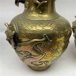 Pair of Chinese brass vases, of ovoid form with elongated neck and fluted rim, decorated in high relief with a dragon chasing a flaming pearl around the neck, the body with dragons, birds and buildings, with character marks beneath, H25cm