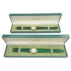 Two Gucci Shelly Line quartz wristwatches, white and green dial with gilt Roman numeral hour markers and GG logo back cases, both on green leather straps and both boxed